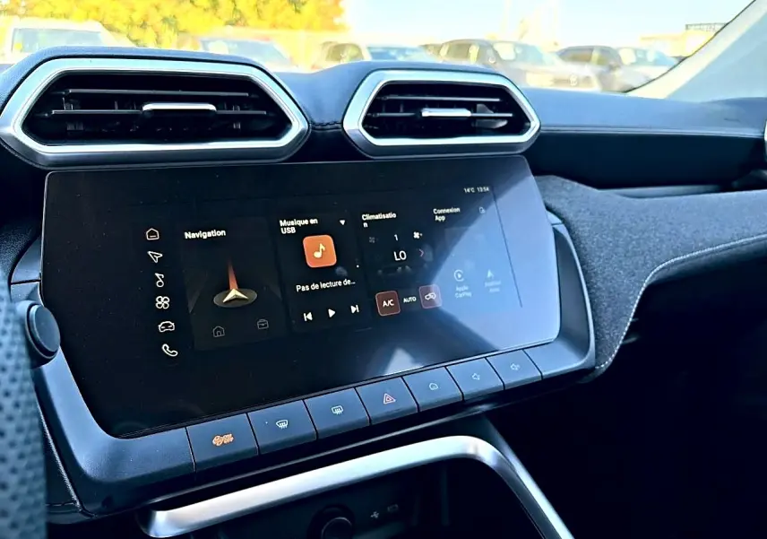 Vue rapprochée de l’écran tactile et des aérateurs hexagonaux du tableau de bord du MG Motor ZS hybride noir.