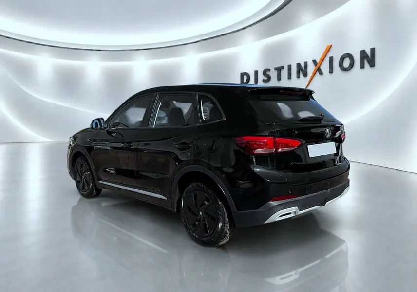 MG Motor ZS hybride noir en vue 3/4 arrière droit dans un showroom lumineux avec logo Distinxion en arrière-plan.