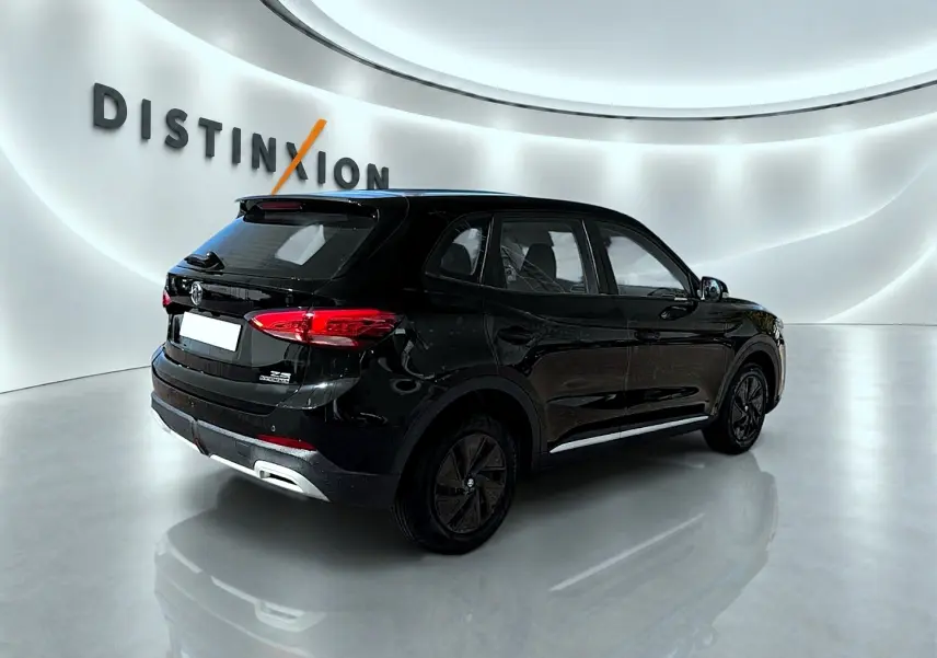 Vue 3/4 arrière droite du SUV MG ZS noir 2026 avec feux arrière LED et becquet arrière dans un showroom lumineux.