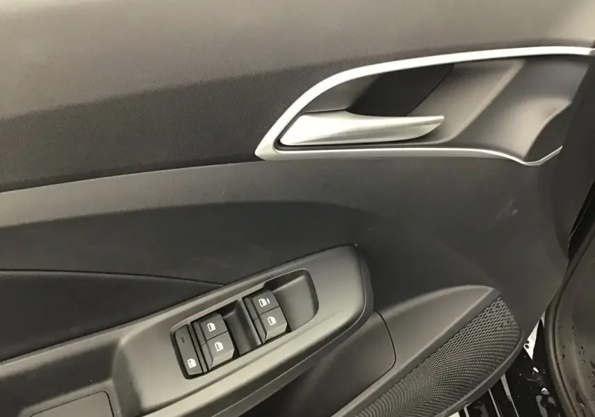 Détail de la porte côté conducteur du MG3 1.5 Hybrid+ Pebble Black, avec commandes de vitres et poignée argentée.