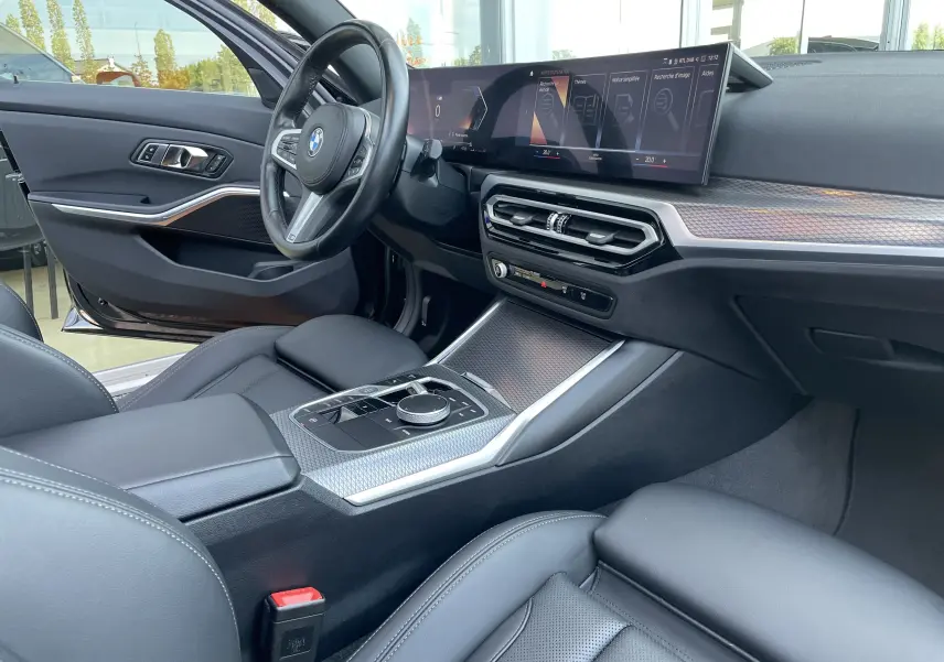 Intérieur noir cuir de la BMW Série 3 Touring G21 xDrive 190 M Sport, vue côté conducteur avec tableau de bord numérique et console centrale moderne.