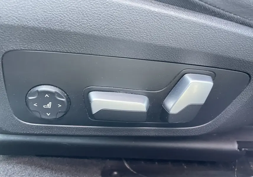 Commandes électriques de réglage du siège côté gauche dans une BMW Série 3 Touring G21 noire, version M Sport 2022.