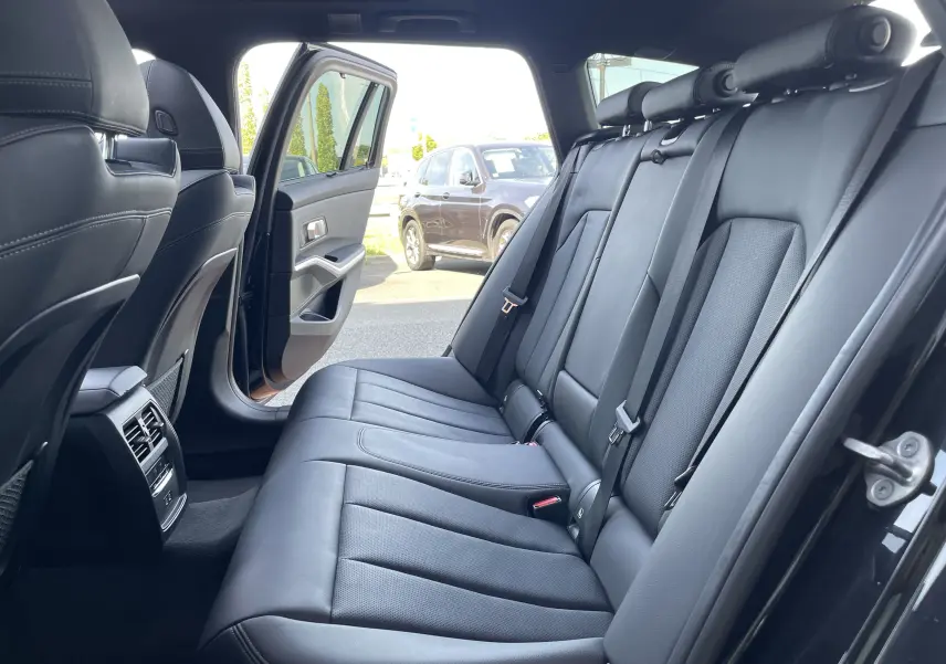 Vue intérieure côté droit sur les sièges arrière en cuir noir de la BMW Série 3 Touring G21 XDrive 190 M Sport 2022.