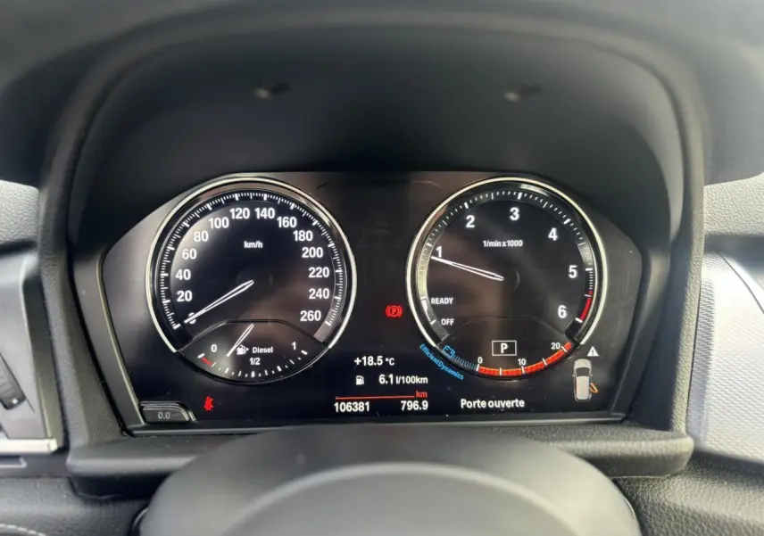 Vue rapprochée du tableau de bord de la BMW Série 2 Active Tourer blanc, affichant compteurs et informations numériques.