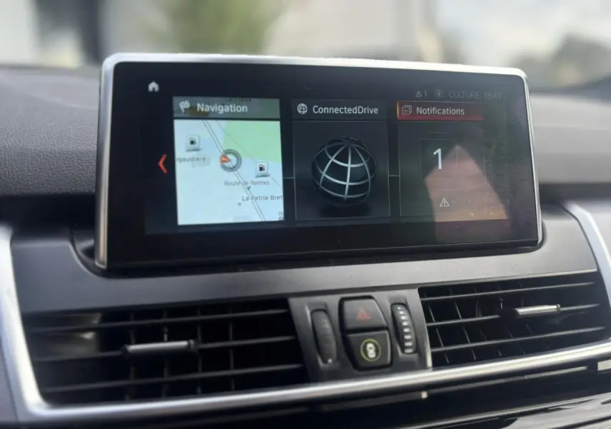 Écran central du GPS de la BMW Série 2 Active Tourer 218dA blanc, affichant la navigation et notifications.