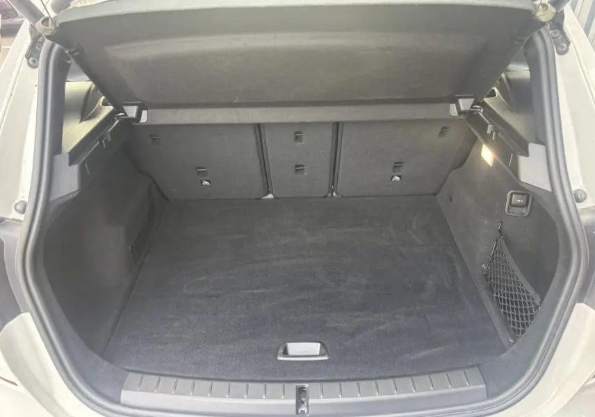 Coffre ouvert d'une BMW Série 2 Active Tourer blanche, montrant un espace de chargement propre et bien éclairé.