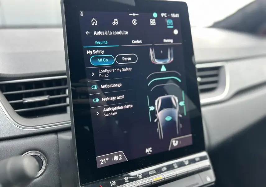 Vue rapprochée de l'écran tactile central du Renault Captur 2025 affichant les aides à la conduite, intérieur gris.