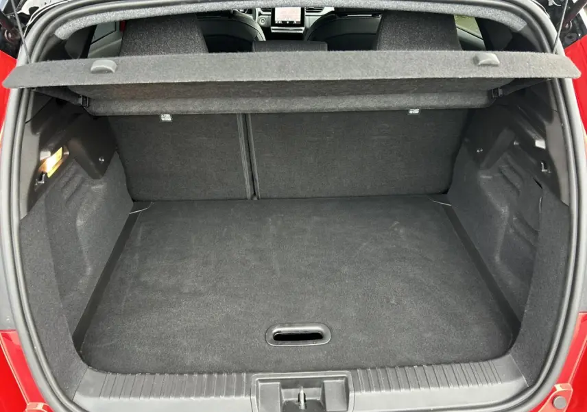 Coffre ouvert vu de l'arrière du Renault Captur Rouge Flamme avec intérieur noir et plancher plat.