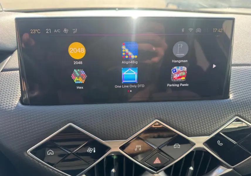 Vue rapprochée de l’écran tactile et des commandes en losange du tableau de bord du DS3 gris 2024.
