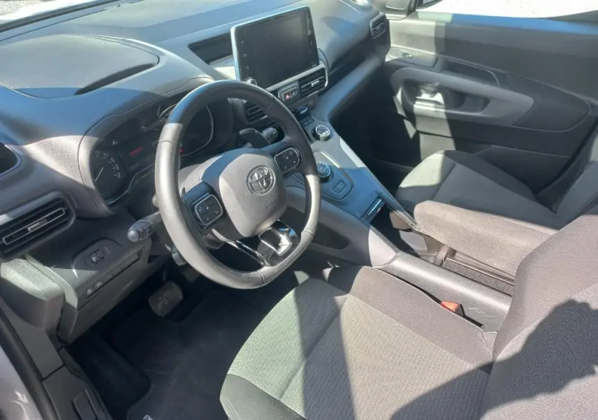 Vue intérieure côté conducteur du Toyota Proace City Verso gris 2023, avec volant multifonction et écran tactile central.