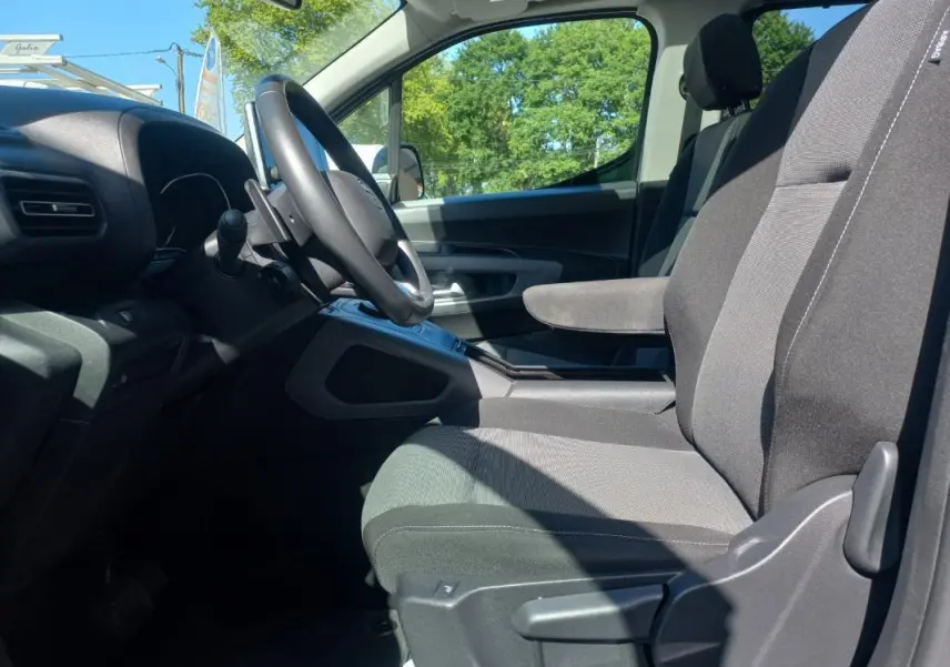Intérieur côté conducteur du Toyota Proace City Verso gris 2023, vue sur sièges et volant avec boîte manuelle.
