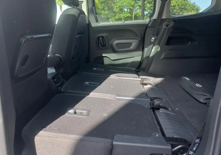 Vue intérieure arrière du Toyota Proace City Verso gris 2023, sièges rabattus pour agrandir le coffre.