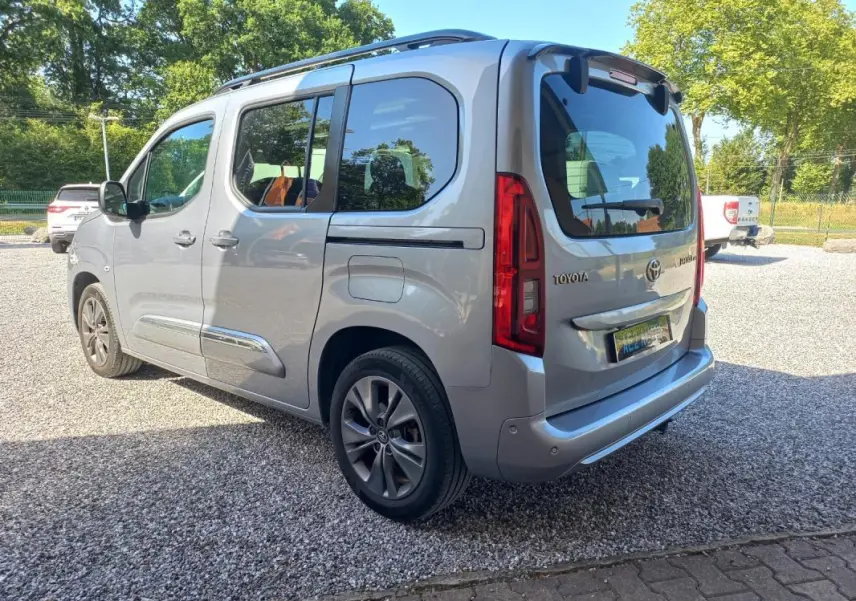 Vue 3/4 arrière droite d'un Toyota Proace City Verso gris 2023, version Medium Executive avec vitres teintées et jantes alliage.