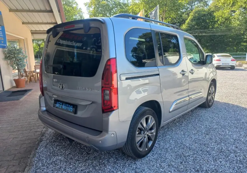 Vue 3/4 arrière droite d'un Toyota Proace City Verso gris 2023, finition Medium Executive avec vitres teintées et jantes alliage.