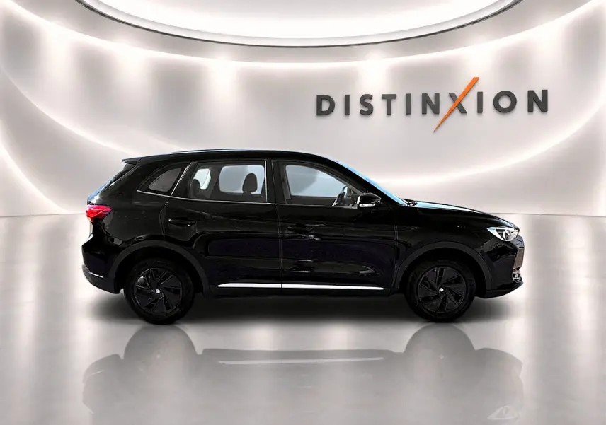 Vue de profil côté gauche du MG ZS 1.5 hybrid noir, avec jantes noires et becquet arrière dans un showroom lumineux.
