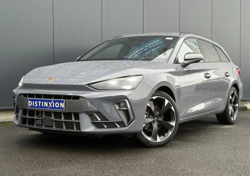 Vue 3/4 avant droite d'une CUPRA LEON ST 2025 gris Graphene avec jantes alliage noires et logo CUPRA sur calandre.