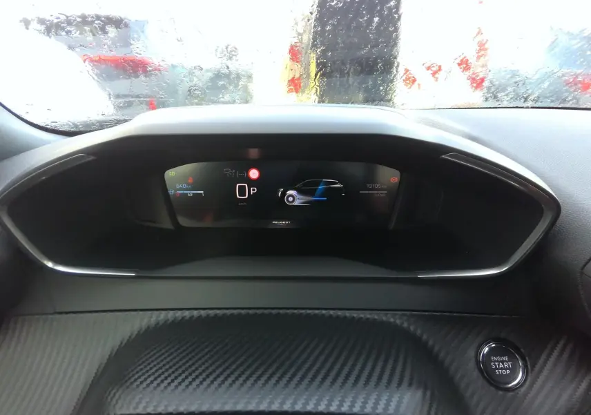 Tableau de bord numérique du Peugeot 2008 hybride, affichage central avec compteur et bouton start/stop visible.