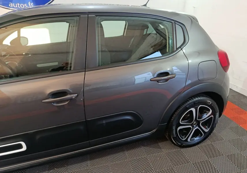 Vue latérale droite d'une Citroën C3 2024 gris foncé avec jantes alliage et protections latérales noires.