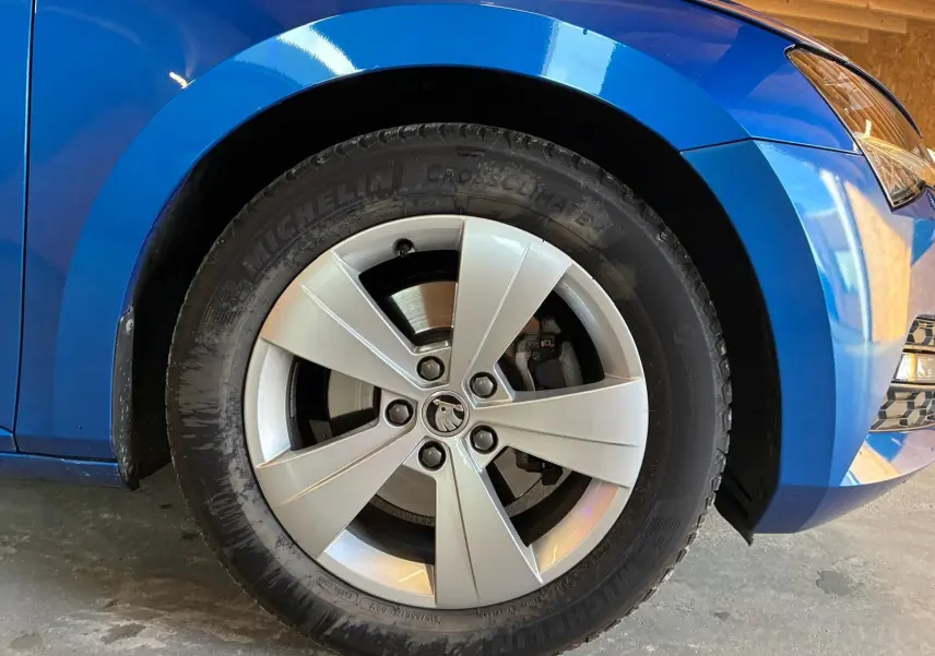 Gros plan sur la roue avant gauche d'une Skoda Superb Combi bleu 2021 avec jante alliage et pneu Michelin.