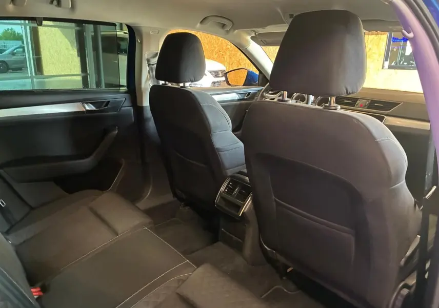Vue intérieure arrière de la Skoda Superb Combi 2021, sièges tissu noirs et aérateurs centraux visibles.