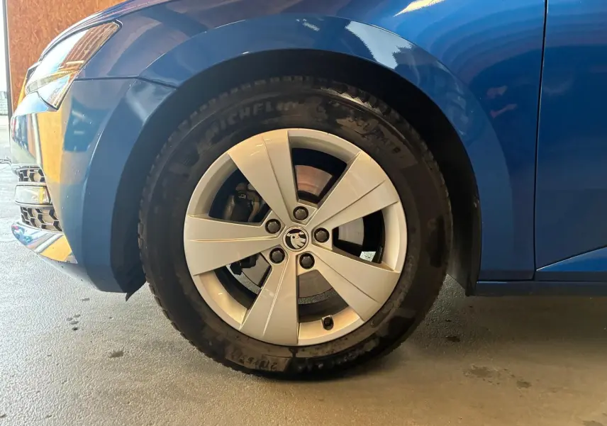 Gros plan sur la roue avant gauche d'une Skoda Superb Combi bleu 2021 avec jante alliage 17 pouces.
