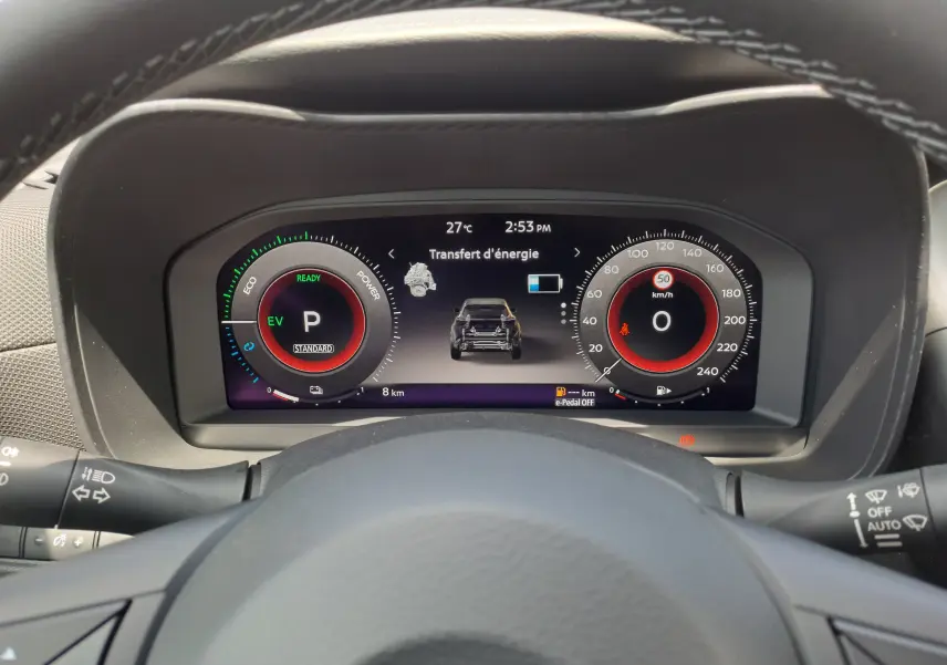 Vue rapprochée du tableau de bord numérique du Nissan Juke Hybrid gris squale, affichant le transfert d'énergie et la vitesse à zéro.