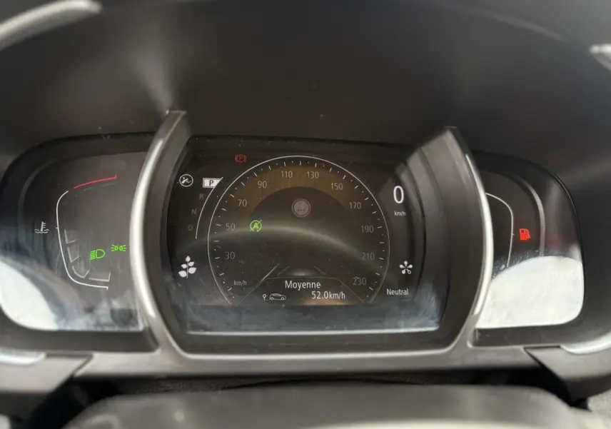 Tableau de bord numérique du Renault Grand Scenic IV, affichant 0 km/h et indicateurs de vitesse moyenne et feux allumés.