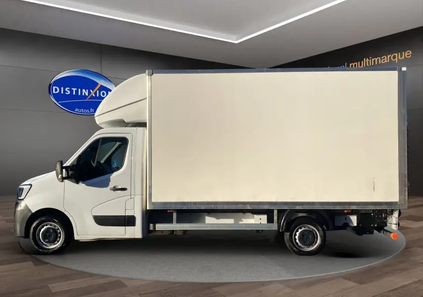 Profil gauche d'un utilitaire blanc Renault Master Châssis Cabine 2023 avec caisse fermée et hayon arrière visible.