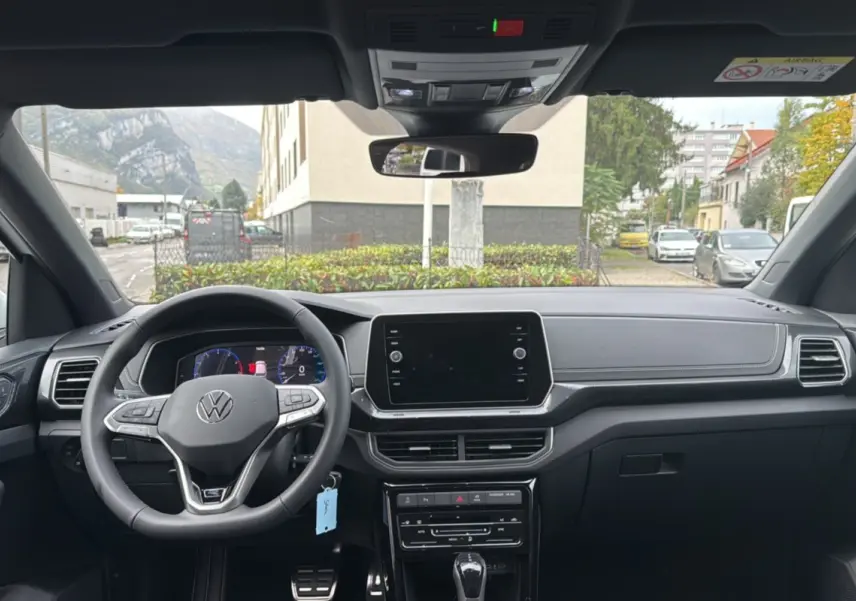 Vue intérieure frontale du tableau de bord et volant cuir multifonctions du Volkswagen T-Cross blanc pur 2025 TSI 116 DSG7 R-Line.