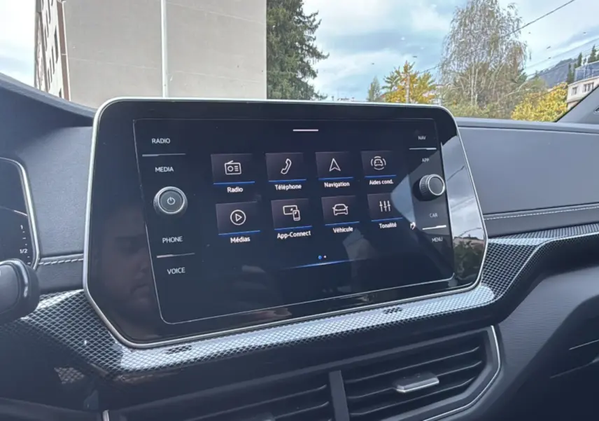 Écran tactile central du tableau de bord du Volkswagen T-Cross blanc pur 2025, avec interface multimédia visible.