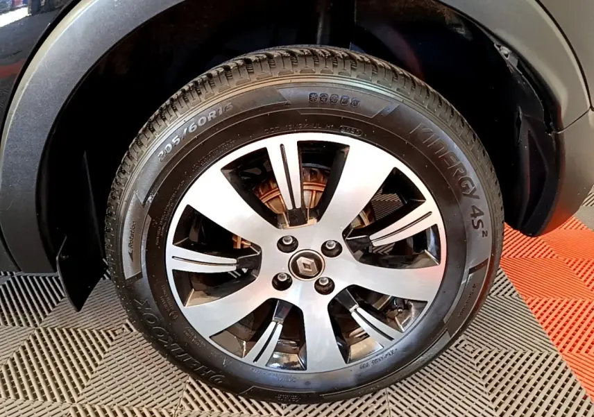 Gros plan sur la roue avant droite du Renault Captur noir, mettant en valeur la jante alliage et le logo central Renault.