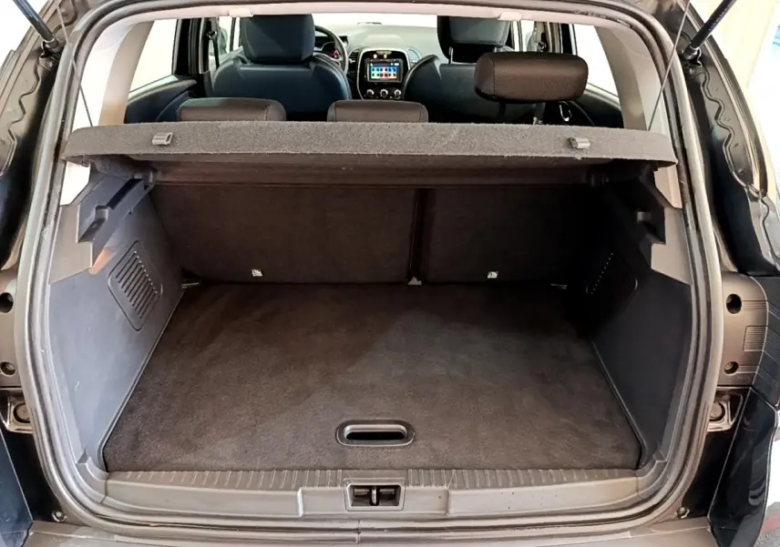 Coffre ouvert vu de l'arrière d'un Renault Captur Business TCe 90 noir, avec tablette cache-bagages en place.