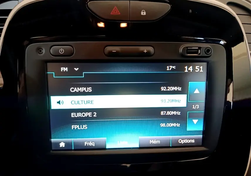 Écran tactile central du tableau de bord du Renault Captur Business noir, affichant les stations radio FM.