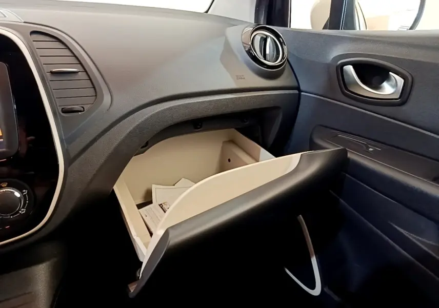 Vue intérieure côté passager du tableau de bord noir avec boîte à gants ouverte du Renault Captur Business TCe 90 2018.