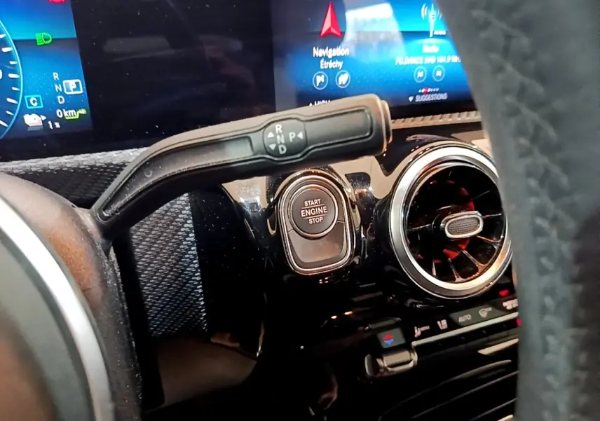 Gros plan intérieur sur le tableau de bord noir d’une Mercedes Classe A avec bouton start/stop et levier de vitesses.