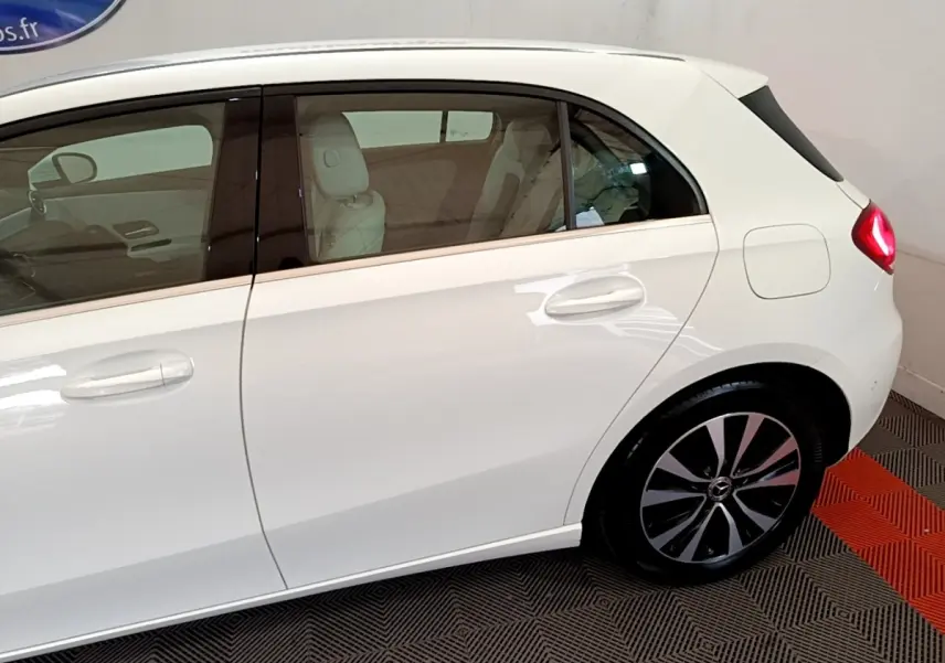 Vue latérale droite d'une Mercedes Classe A Berline A 250 e Business Line blanche, avec jantes alliage et vitres teintées.