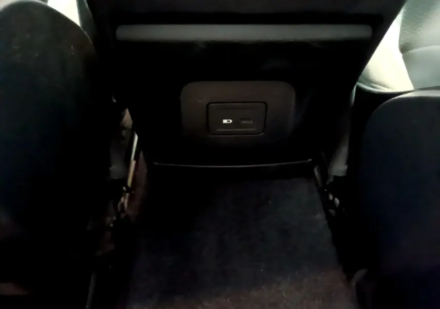 Vue rapprochée de la prise USB située à l'arrière des sièges noirs de la Mercedes Classe A Berline blanche.