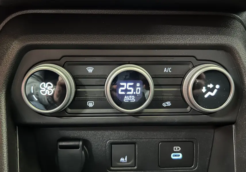 Gros plan sur la commande de climatisation digitale du Dacia Jogger gris schiste, affichant 25°C en mode automatique.