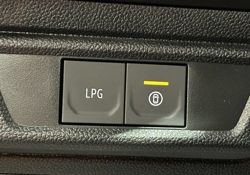 Gros plan sur les boutons de commande LPG et verrouillage centralisé dans l’habitacle noir du Dacia Jogger gris Schiste Metal.