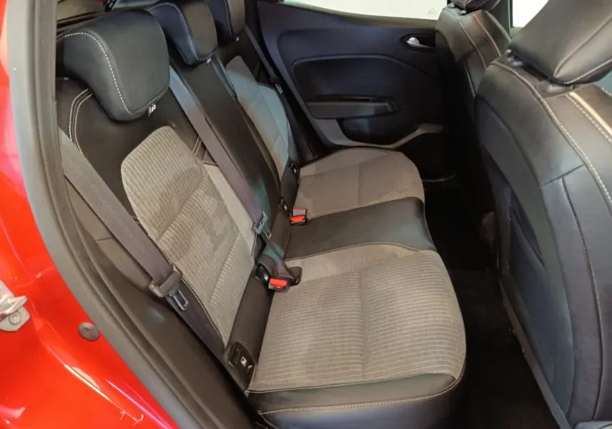 Vue intérieure côté gauche de la banquette arrière en tissu et cuir noir de la Renault Clio rouge 2024.