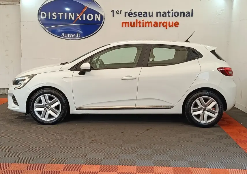 Profil côté gauche d'une Renault Clio Business TCe 100 GPL blanche, avec jantes alliage et antenne de toit visible.