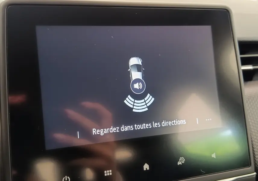 Écran tactile intérieur de la Renault Clio Business blanc, affichant une alerte de détection d’obstacle sonore.