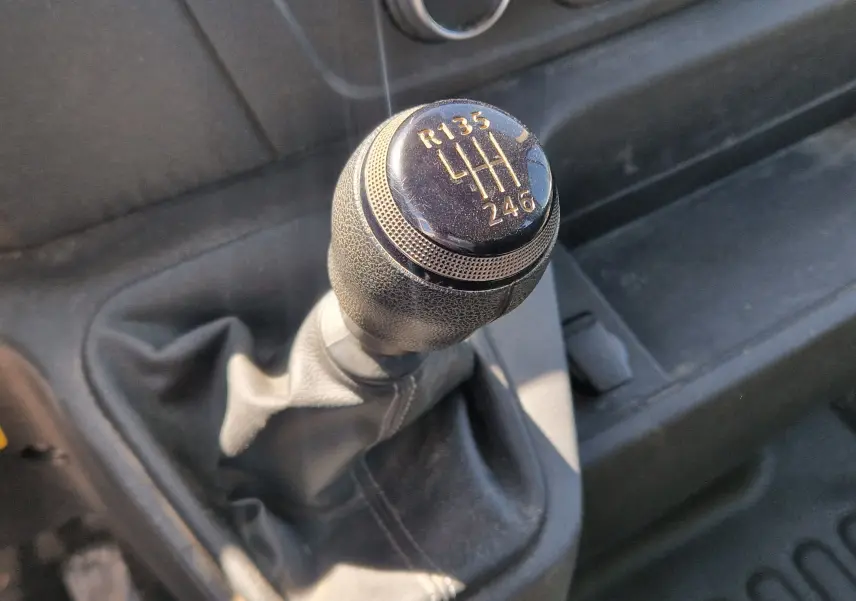 Vue latérale droite du Renault Master blanc avec benne et coffre latéral fermé, sous un ciel bleu dégagé.