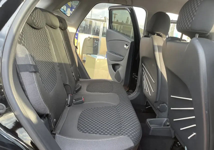 Vue intérieure arrière côté gauche du Renault Captur noir étoile, sièges tissu gris beige avec motifs géométriques.