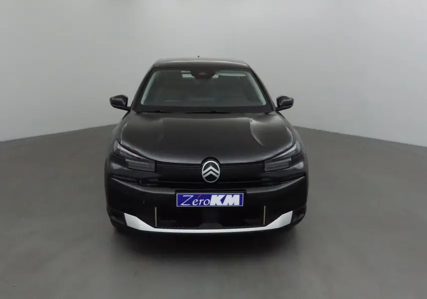 Citroën C4 noire vue de face, mettant en valeur sa calandre moderne et ses phares fins dans un studio neutre.