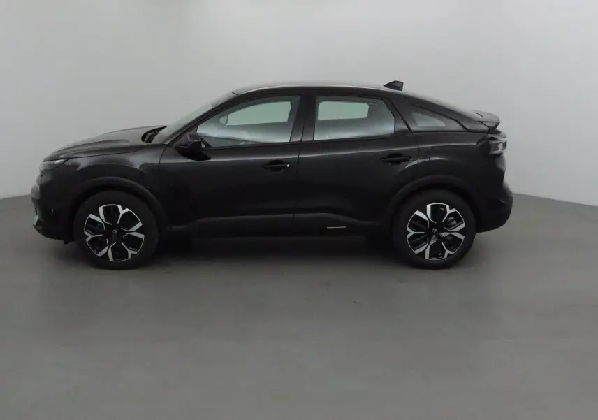 Profil côté gauche d'une Citroën C4 noire 2025, avec jantes alliage noires et détails modernes sur un fond neutre.