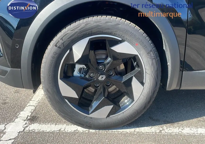 Gros plan sur la roue avant gauche du Renault Captur noir étoile métal avec jante noire et argentée au design étoilé.