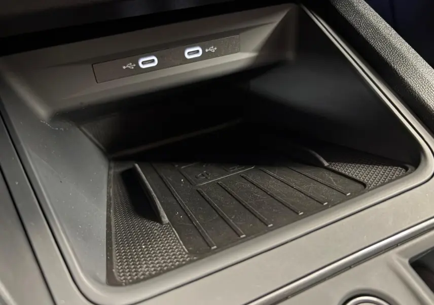 Gros plan sur le compartiment de recharge sans fil avec deux ports USB-C illuminés dans une CUPRA Formentor Noir Minuit.