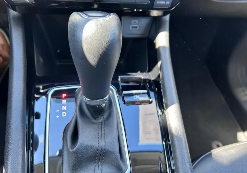 Gros plan sur la commande de boîte automatique noire du Jeep Compass 2024 avec indicateur de vitesse et frein de parking électronique.