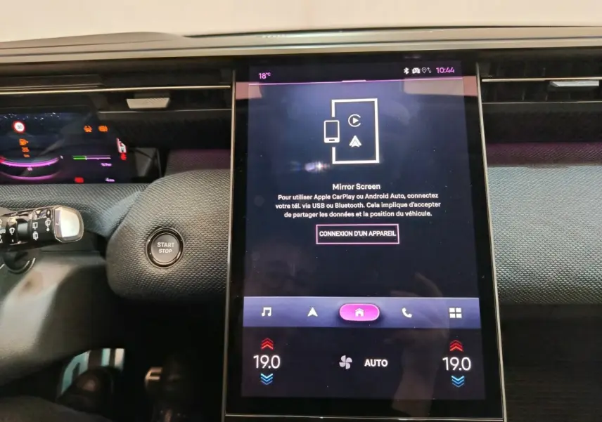 Vue intérieure centrée sur l'écran tactile vertical du tableau de bord de la Citroën C5 hybride gris foncé.